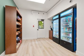A room with a vending machine and a shelf with snacks.